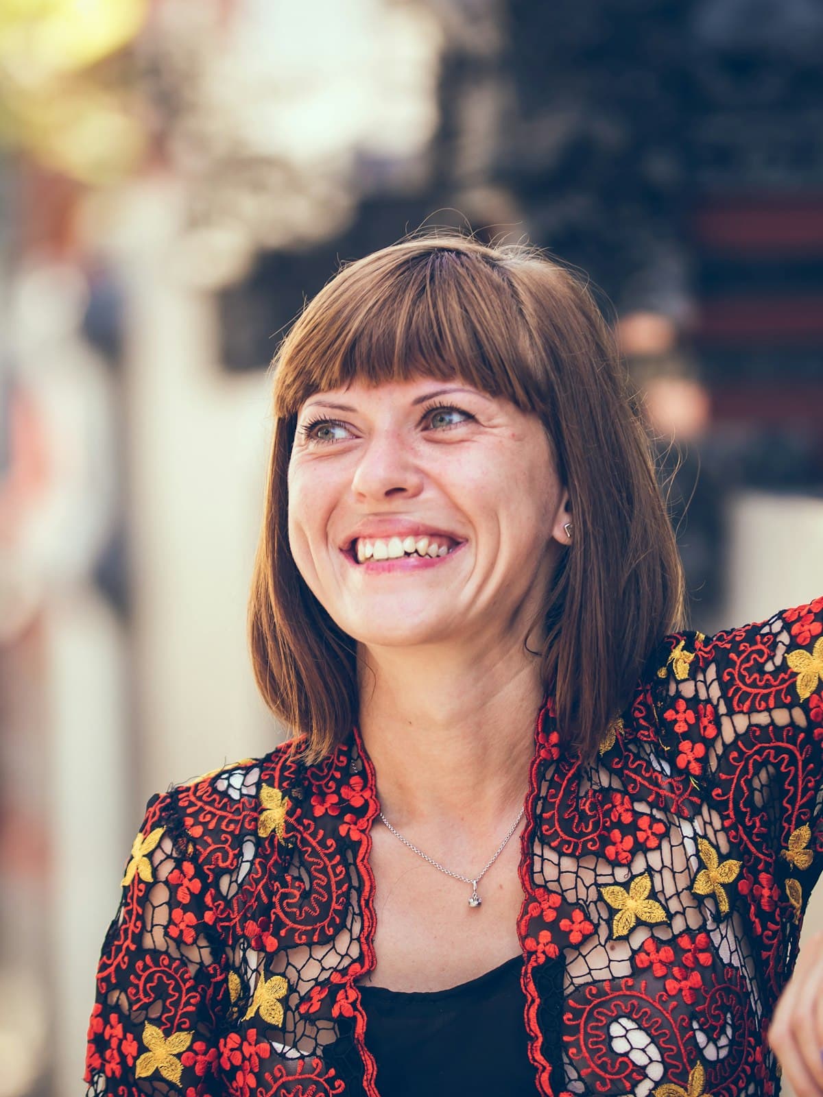 A woman in a patterned jacket laughing
